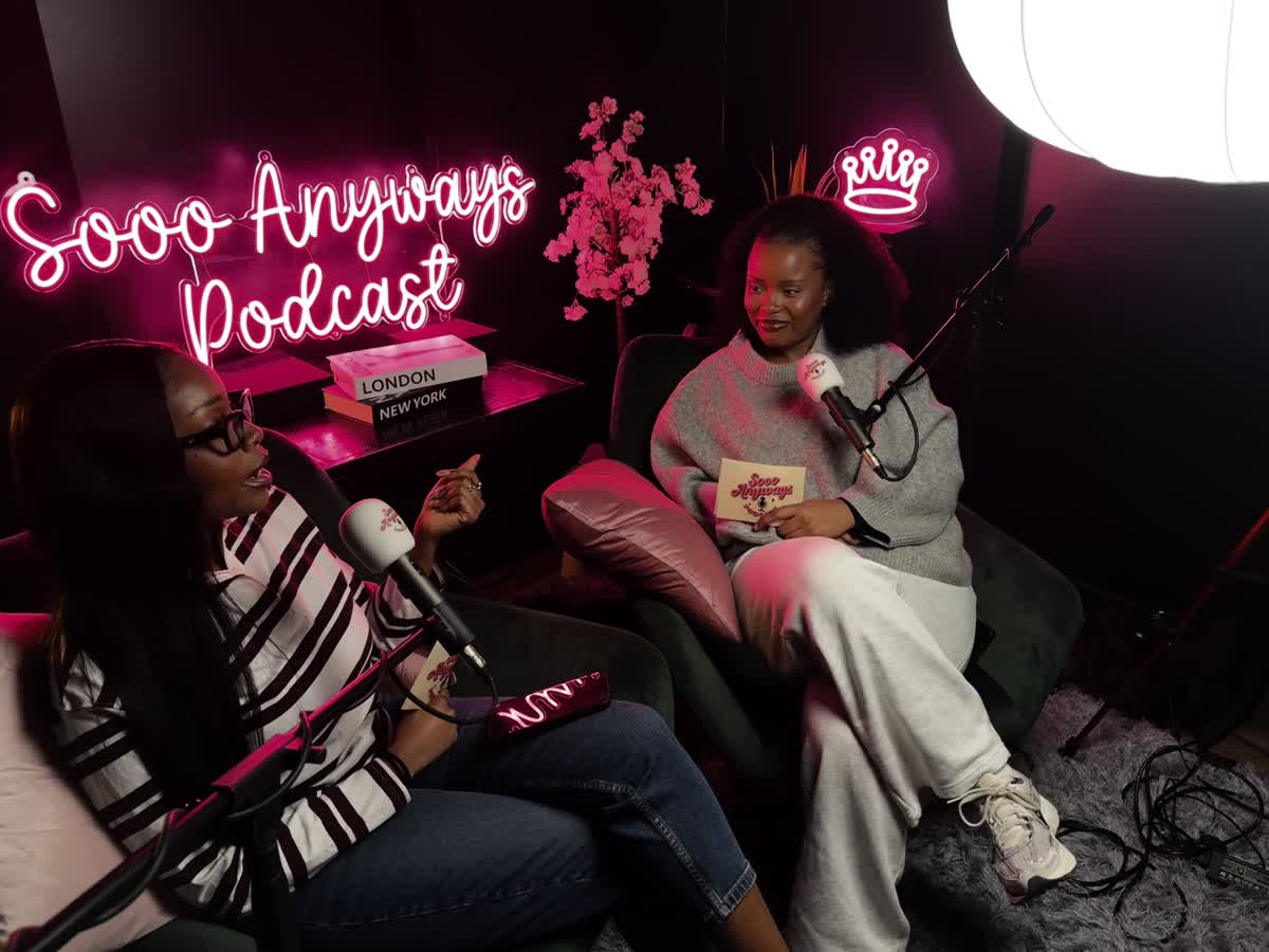 A smile between conversations in our pink-lit podcast studio
